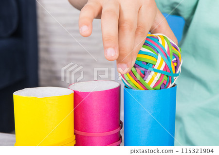 Preschooler hands with ball of rubber bands or erasers Preschooler hands with ball of rubber bands or erasers 115321904