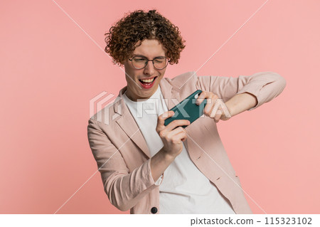 Happy man playing racing drive simulator shooter video games on smartphone celebrate victory win Happy man playing racing drive simulator shooter video games on smartphone celebrate victory win 115323102