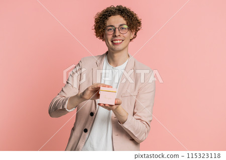 Smiling young man presenting jewelry gift present box stretches out hands promotion discount sale Smiling young man presenting jewelry gift present box stretches out hands promotion discount sale 115323118