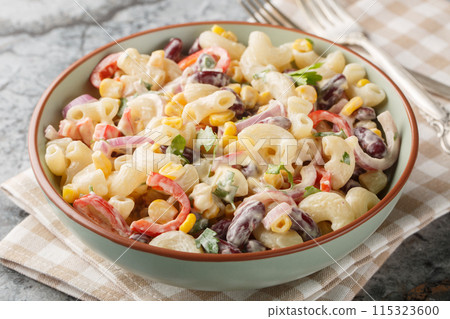 Delicious American macaroni pasta salad with onions, corn, beans, peppers with ranch dressing close-up in a bowl. Horizontal Delicious American macaroni pasta salad with onions, corn, beans, peppers with ranch dressing close-up in a bowl. Horizontal 115323600