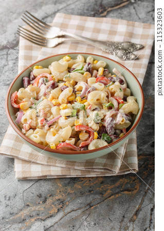 Southwestern pasta salad is a zesty summer side filled with fresh corn, onion, beans, peppers with creamy homemade ranch style dressing closeup on the bowl. Vertical Southwestern pasta salad is a zesty summer side filled with fresh corn, onion, beans, peppers with creamy homemade ranch style dressing closeup on the bowl. Vertical 115323603