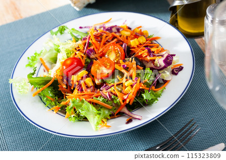 Appetizing salad of various vegetables - lettuce, tomatoes, corn, onions 115323809