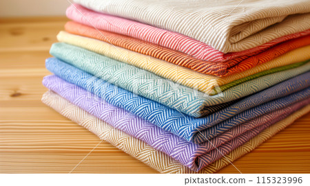 Colorful folded fabrics with distinct textures on wood. 115323996