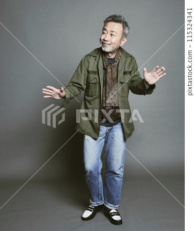 Portrait of a middle-aged man in casual clothes against a gray background 115324341