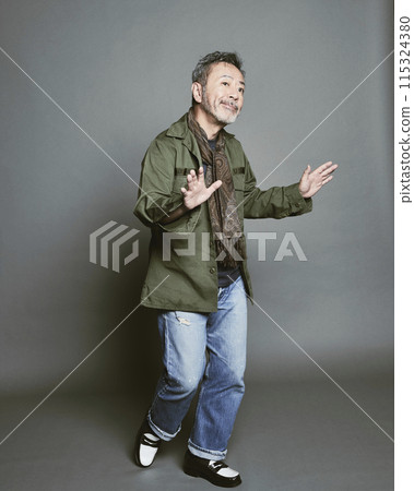 Portrait of a middle-aged man in casual clothes against a gray background 115324380