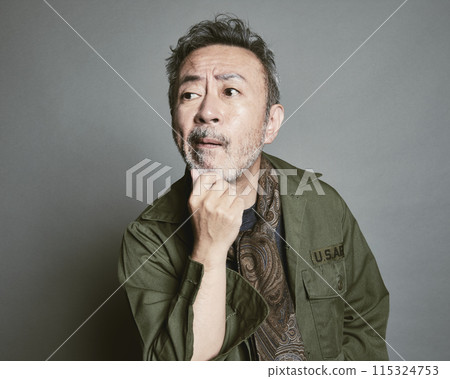 Portrait of a middle-aged man in casual clothes against a gray background 115324753