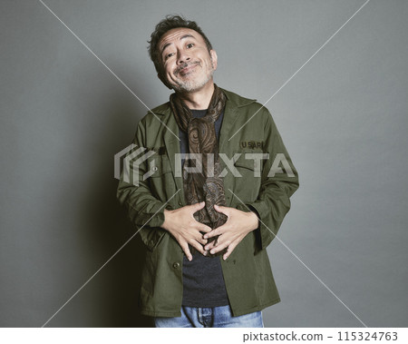Portrait of a middle-aged man in casual clothes against a gray background 115324763