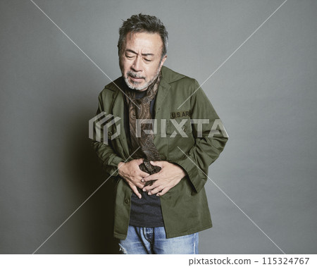 Portrait of a middle-aged man in casual clothes against a gray background 115324767