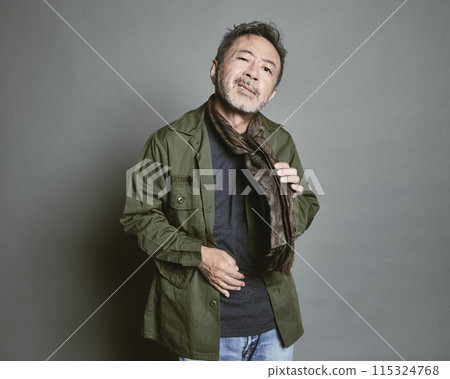 Portrait of a middle-aged man in casual clothes against a gray background 115324768