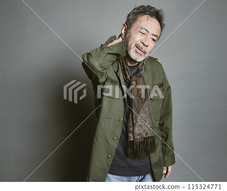 Portrait of a middle-aged man in casual clothes against a gray background 115324771