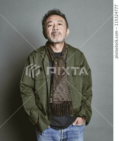 Portrait of a middle-aged man in casual clothes against a gray background 115324777