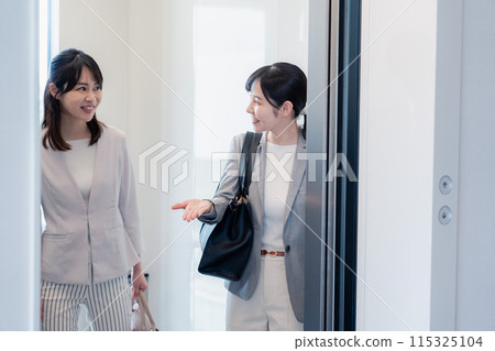 Two business people sharing an elevator Two business people sharing an elevator 115325104