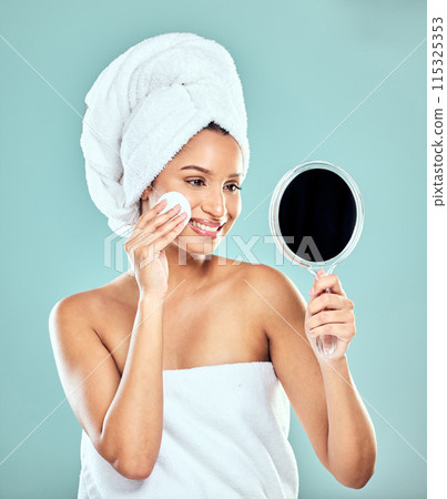 Woman, cotton pad and skincare with mirror in studio for wellness, health and face products. Female person, beauty and cosmetic for results, pride and dermatology for glowing skin in blue background Woman, cotton pad and skincare with mirror in studio for wellness, health and face products. Female person, beauty and cosmetic for results, pride and dermatology for glowing skin in blue background 115325353
