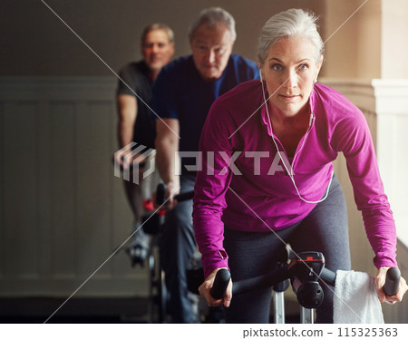 Spin class, gym or senior woman on bike in workout or training for cycling progress, health or wellness. Group, challenge or confident elderly person on bicycle machine for fitness or cardio exercise 115325363