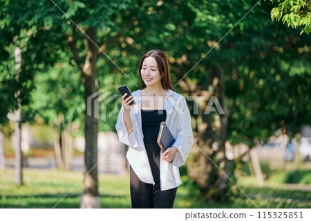 A young woman operating a smartphone A young woman operating a smartphone 115325851