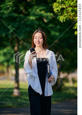A young woman operating a smartphone 115325854