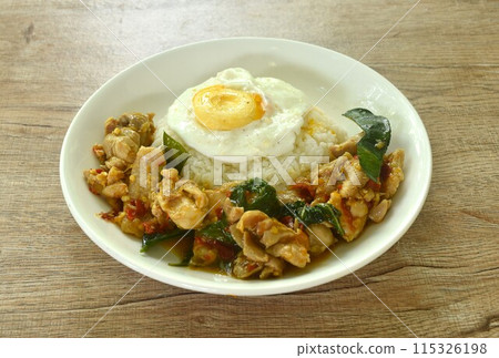 spicy stir fried chicken with mashed dry chili and basil on rice topping egg in plate 115326198