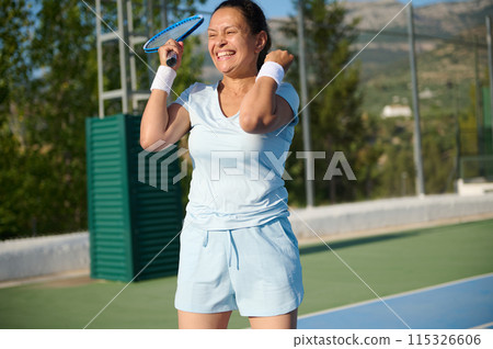 Woman in her 40s playing tennis on a sunny day outdoors 115326606