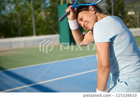 Middle-aged woman playing tennis on an outdoor court Middle-aged woman playing tennis on an outdoor court 115326610