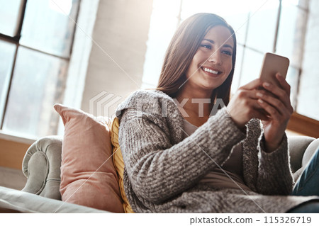 Phone, smile and happy woman relax on a sofa with social media, streaming or reading subscription sign up info at home. Smartphone, app and person in a living room with online dating, chat or scroll 115326719