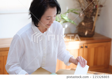 中年婦女將一封信放入紙箱以獲得零用錢 115326803