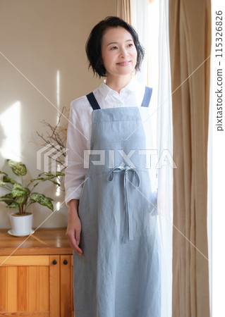 在客廳裡操作智能手機的中年女人 在客廳裡操作智能手機的中年女人 115326826