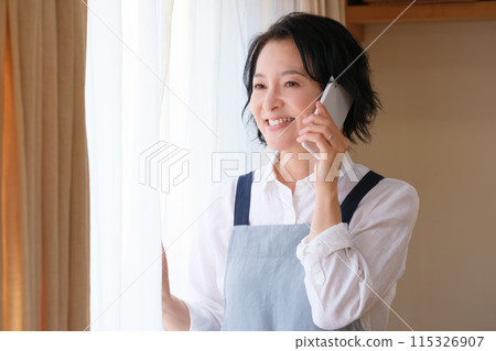 中年婦女在客廳打電話給家人 115326907