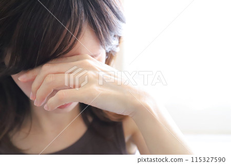 A woman looking down and worried 115327590
