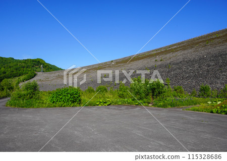 The rockfill dam body of the Chubetsu Dam seen from the Chubetsu Dam Downstream Plaza 115328686