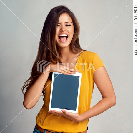 Excited woman, portrait and display with tablet screen for advertising, marketing or app on a studio background. Happy female person, model or smile for technology or presentation on mockup space 115329012