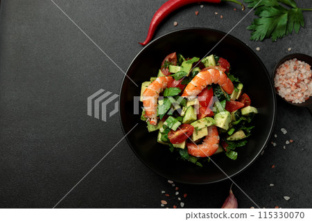 Salad of king prawns, avocado, cucumber, tomato and herbs. Black background Salad of king prawns, avocado, cucumber, tomato and herbs. Black background 115330070