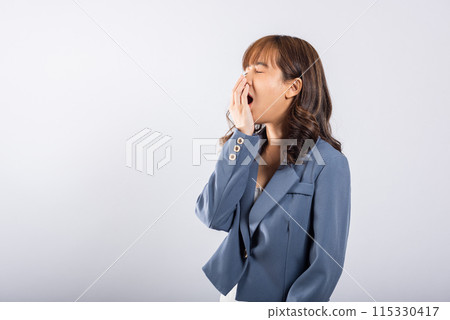 Portrait Asian beautiful young business woman emotions tired and sleepy her yawning covering mouth open by hand, studio shot isolated on white background, Female insomnia concept with copy space Portrait Asian beautiful young business woman emotions tired and sleepy her yawning covering mouth open by hand, studio shot isolated on white background, Female insomnia concept with copy space 115330417