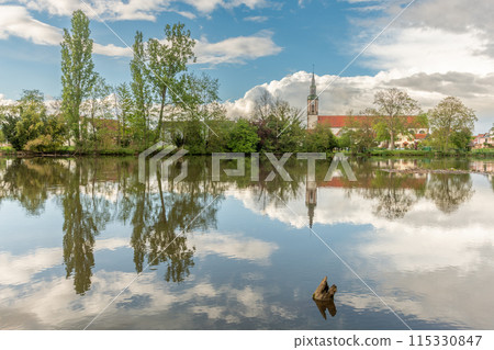 Huttenheim village reflected in a natural tree-lined river in spring. Huttenheim village reflected in a natural tree-lined river in spring. 115330847