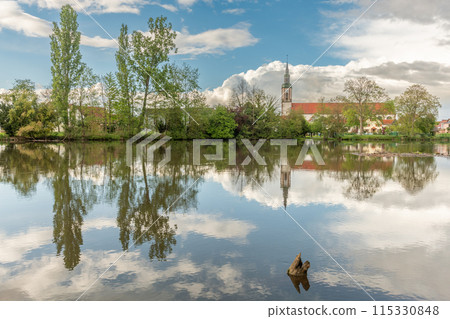 Huttenheim village reflected in a natural tree-lined river in spring. Huttenheim village reflected in a natural tree-lined river in spring. 115330848