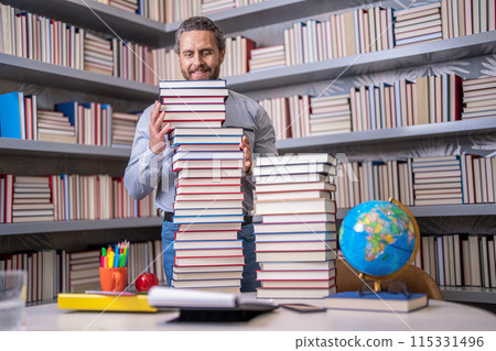 Man with books in library. Knowledge and education. Absorbed in a book. school library. Teachers day. Teacher in school classroom. teacher with book in library classroom. Hispanic teacher in college 115331496