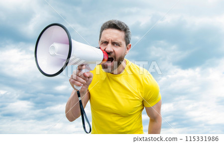 man in yellow shirt shout in loudspeaker on sky background. advertisement man in yellow shirt shout in loudspeaker on sky background. advertisement 115331986