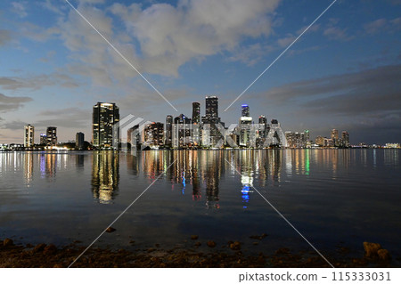 City of Miami in evening twilight reflected in calm water of Biscayne Bay. 115333031
