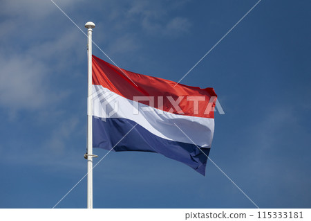 Dutch flag waving atop of its pole 115333181