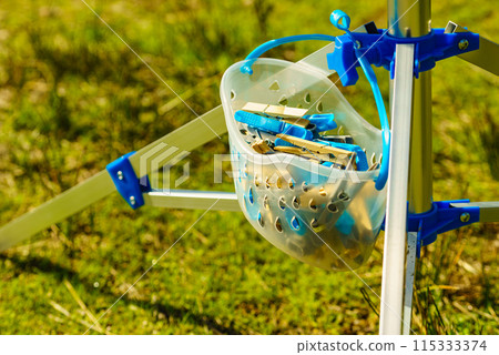 Drier and cloths pins in bucket used for hanging wet laundry 115333374