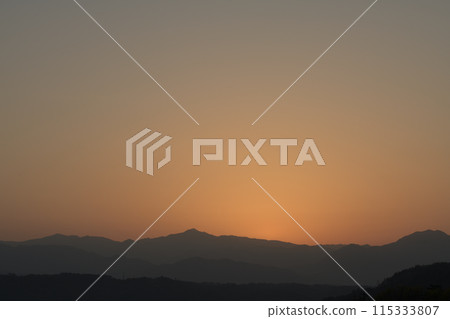 Viewed from Hakushu-cho, Hokuto City. The sun rises from the foot of Mount Kinpu, painting the eastern sky red and golden. 115333807