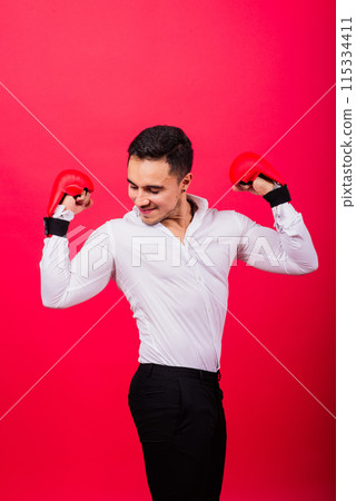 Handsome young businessman with boxing gloves. Studio red background 115334411