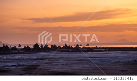 Sunset at the border of Djibouti and Ethiopia with limestone chimneys geological rock formations in a sunset rays with salt lake Abbe in background, Dikhil region, Djibouti Sunset at the border of Djibouti and Ethiopia with limestone chimneys geological rock formations in a sunset rays with salt lake Abbe in background, Dikhil region, Djibouti 115335412