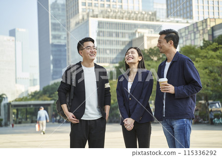 young asian adults standing talking on street young asian adults standing talking on street 115336292
