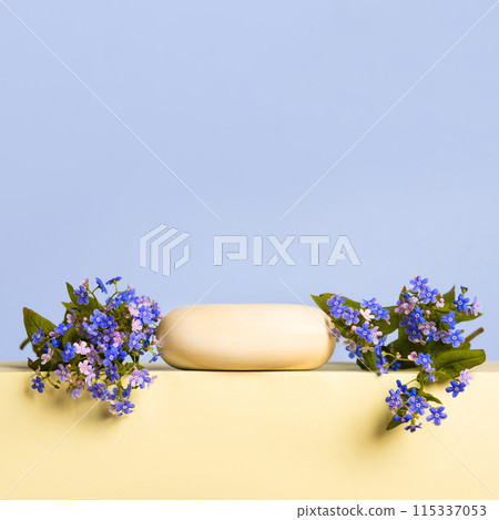 Wood stones and blue flowers brunnera sibirica on yellow podium on blue background. Concept scene stage showcase for new product, banner, promotion sale, cosmetic, presentation 115337053