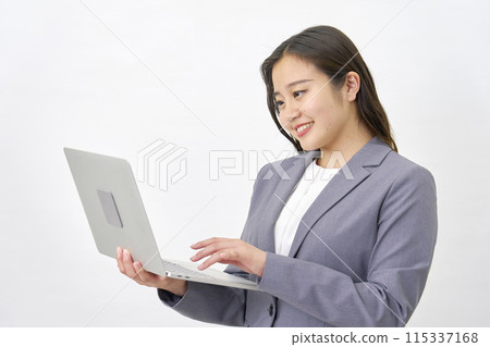Young business woman using a laptop computer, white background 115337168