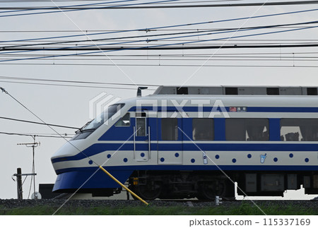 A Tobu Ryomo Express train wrapped in blue polka dots speeding by A Tobu Ryomo Express train wrapped in blue polka dots speeding by 115337169
