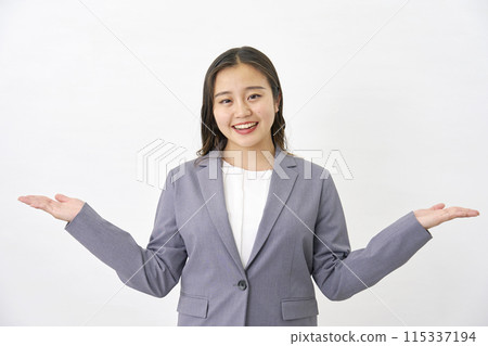 Young business woman pointing left and right with palms on white background 115337194