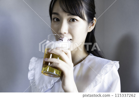 Woman drinking beer 115337262