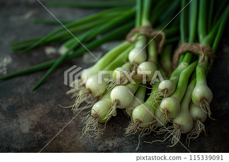 Fresh spring onions on a board. Dark rustic style. 115339091