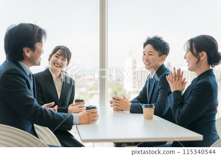 Businessmen and women chatting in the office cafe space Businessmen and women chatting in the office cafe space 115340544